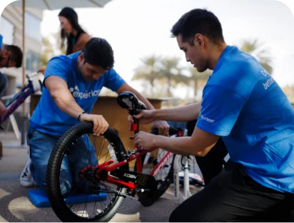 Two volunteers building a blue bike