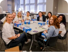 Volunteers at a table decorating superhero boxes