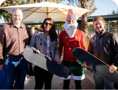 4 volunteers posing with skateboards