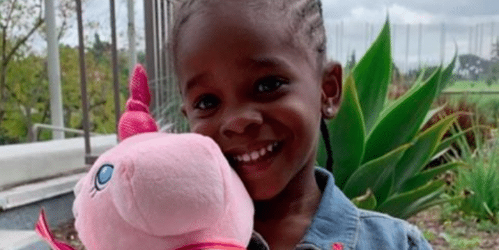 black little girl with her pink stuff toy