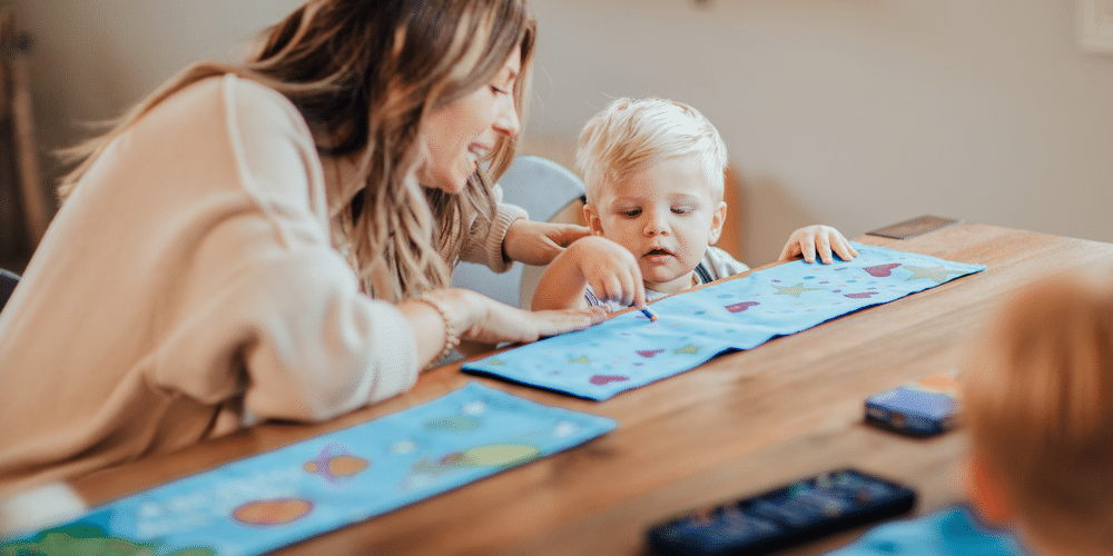 woman and toddler in preschool decorating Giving Back Boxes