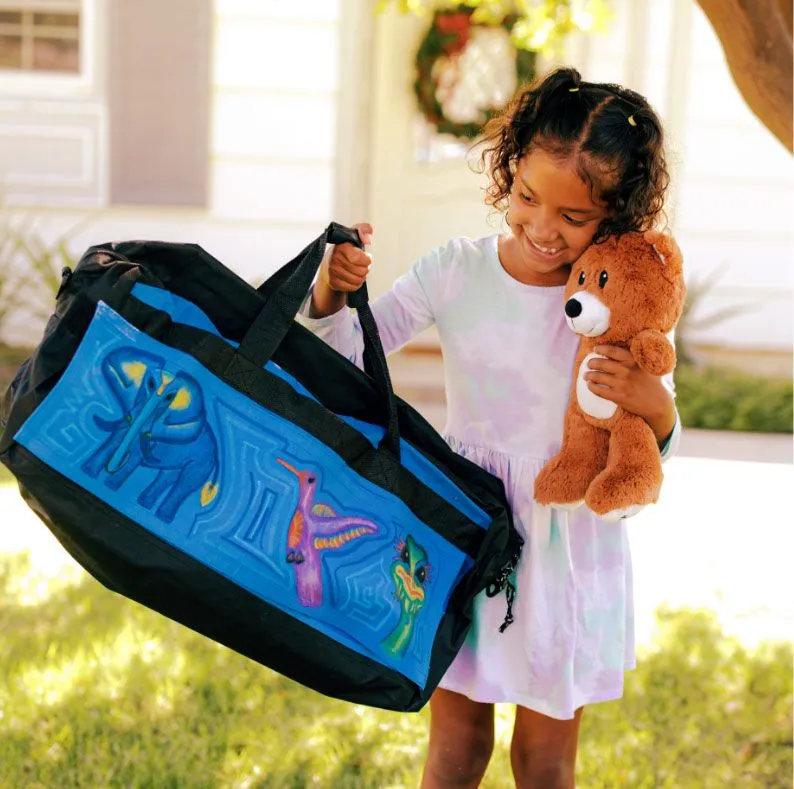 girl with bear holding up sweet case luggage for children in foster care