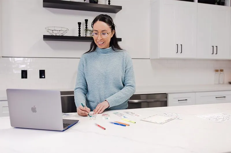 Woman building a virtual STEM kit in front of a laptop