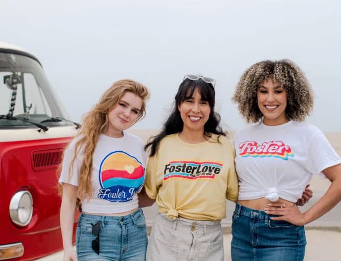 3 girls wearing Foster Love shirts at the beach