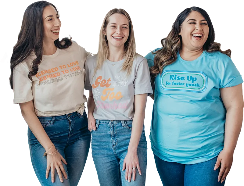 Three women wearing Foster Love merch t shirts