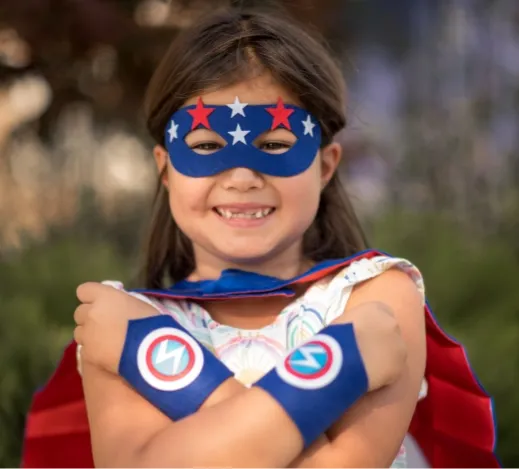 Girl showing off her superhero armbands and mask