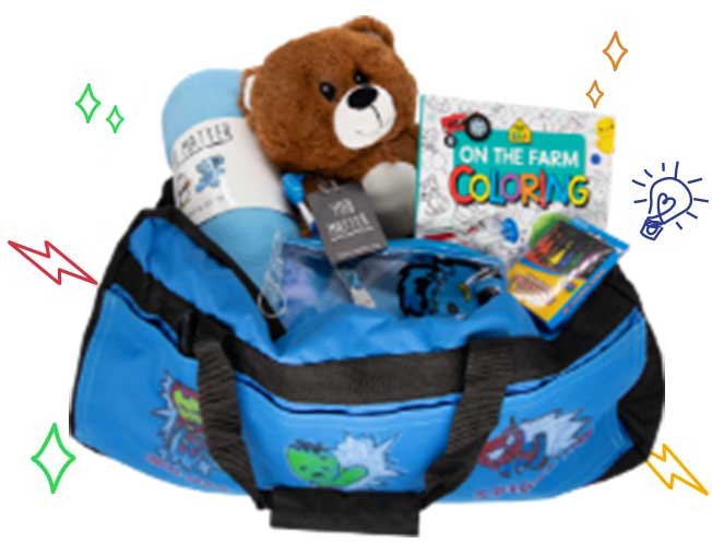 A Sweet Case bag, opened and showing off the items packaged inside including a teddy bear, blanket, and coloring book.