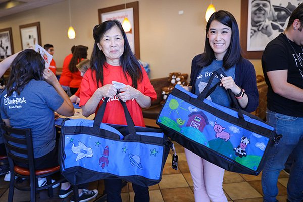 two volunteers holding up decorated sweet cases