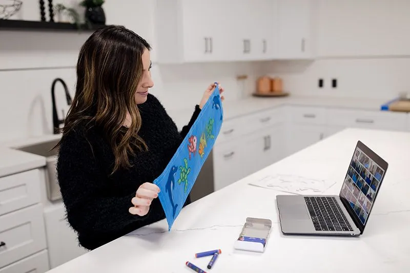 Woman holding finished Sweet Case panel up to laptop