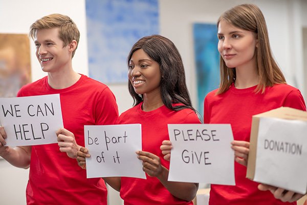 young-volunteers-holding-up-signs.original