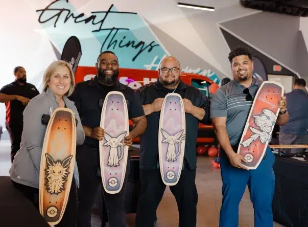 Gallery_3 4 people showing off Pokemon skateboards they helped assemble