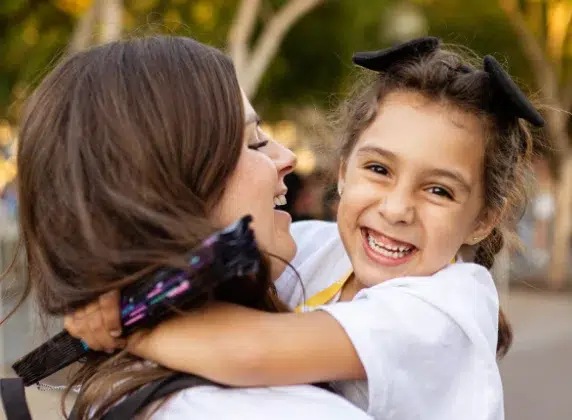 Little girl looking at camera being held by volunteer