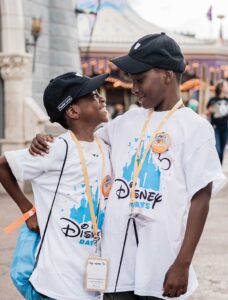 two brothers with their arms on each others' shoulders at Disney Days