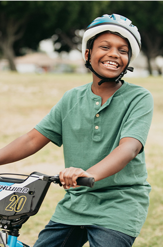 Boy wearing green posing on his new bicycle