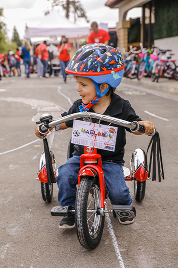 Boy wearing helmet riding his new tricycle