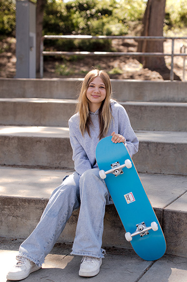 Girl sitting on steps with her skateboard