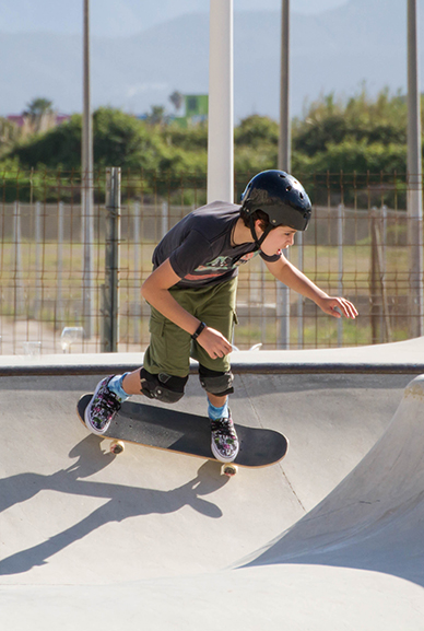 Boy riding a skateboard doing a trick in a skate bowl