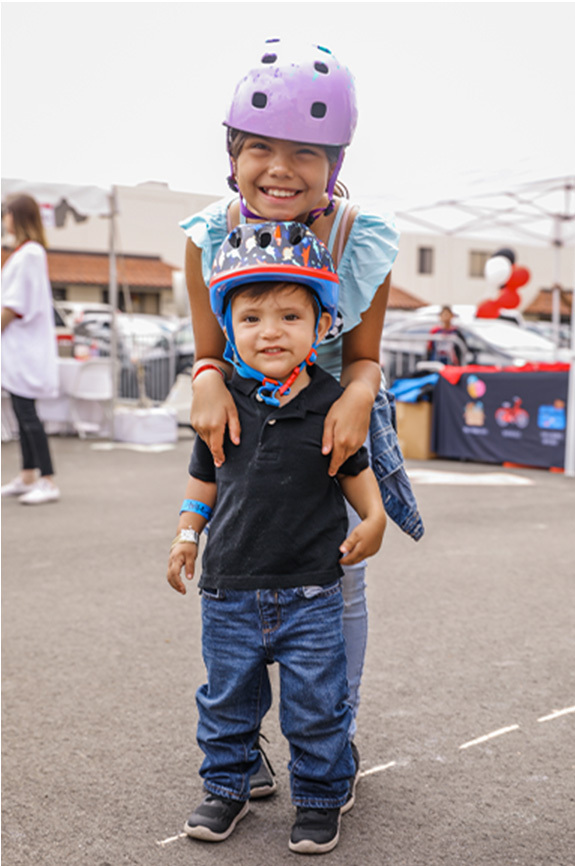 Girl and boy posing while wearing helmets