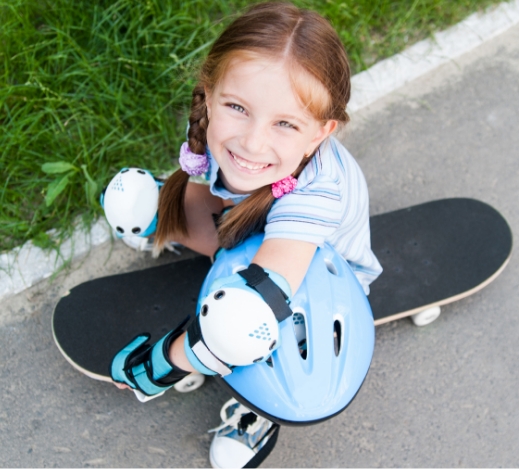 Girl looking up at the camera with her skateboard