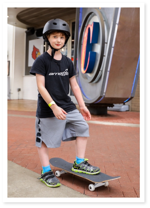 Boy wearing helmet posing on his new skateboard