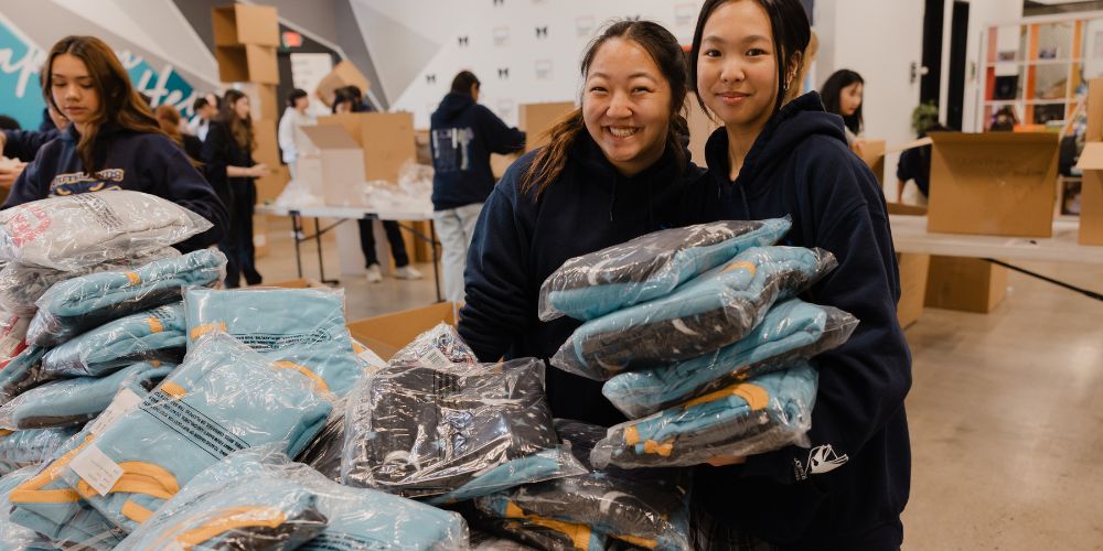 two volunteers holding bags learning how can you help people in foster care