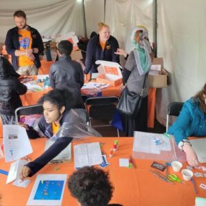 Avery at a table helping children with science activities