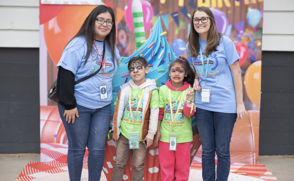Volunteers posing with children at their Birthday Palooza