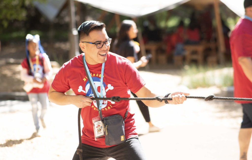 A volunteer playing tug o war at Birthday Palooza