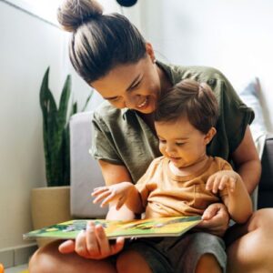 woman with toddler in her lap reading a book