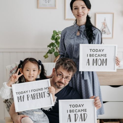 family holding adoption day signs