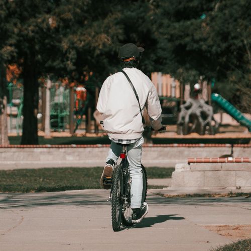 boy riding bike through park